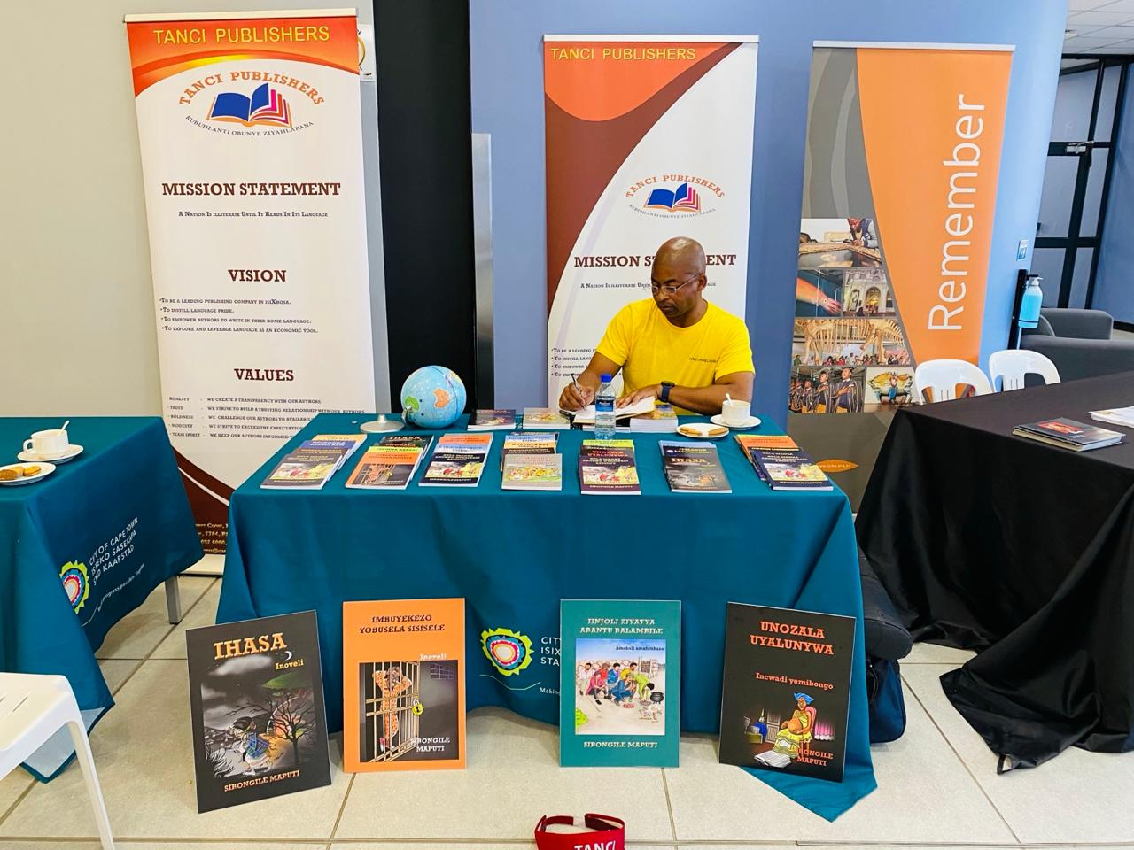 Tanci Publishers books and mission display at a publishing event
